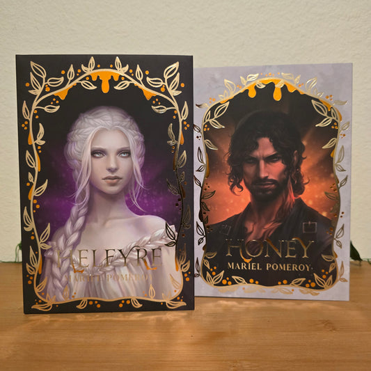 Two book covers with artistic designs on a wooden surface.