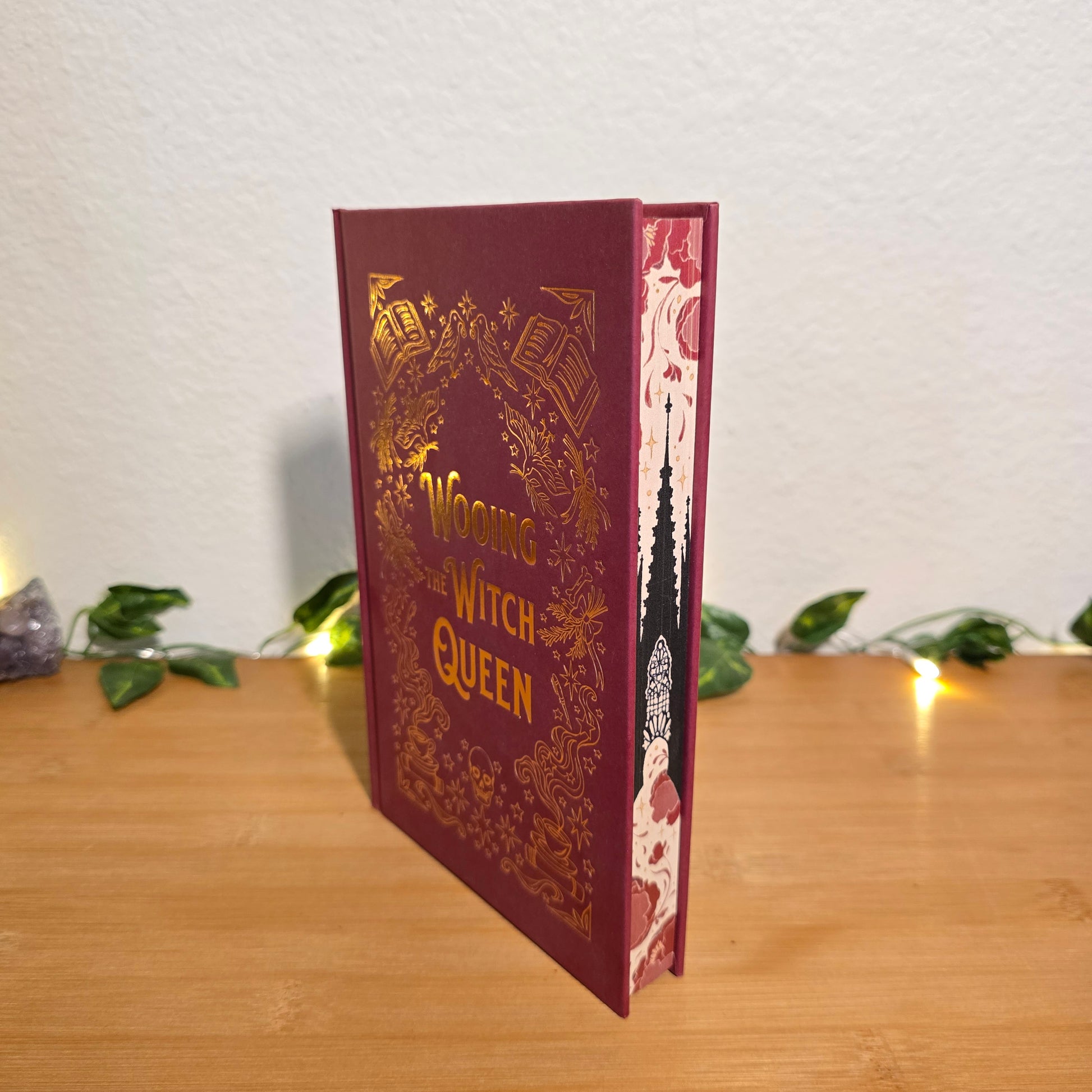 Decorative book-shaped light on a shelf with a white wall and wooden surface in the background.