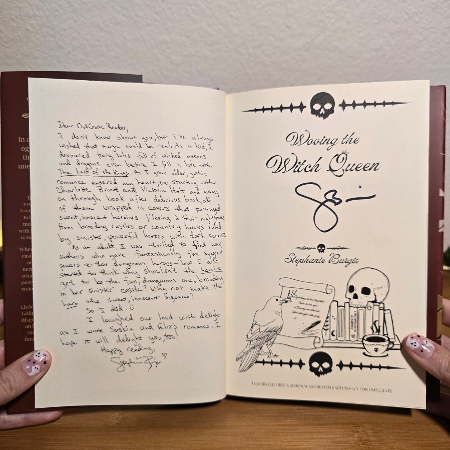 Open book with handwritten text and illustrations on a wooden surface