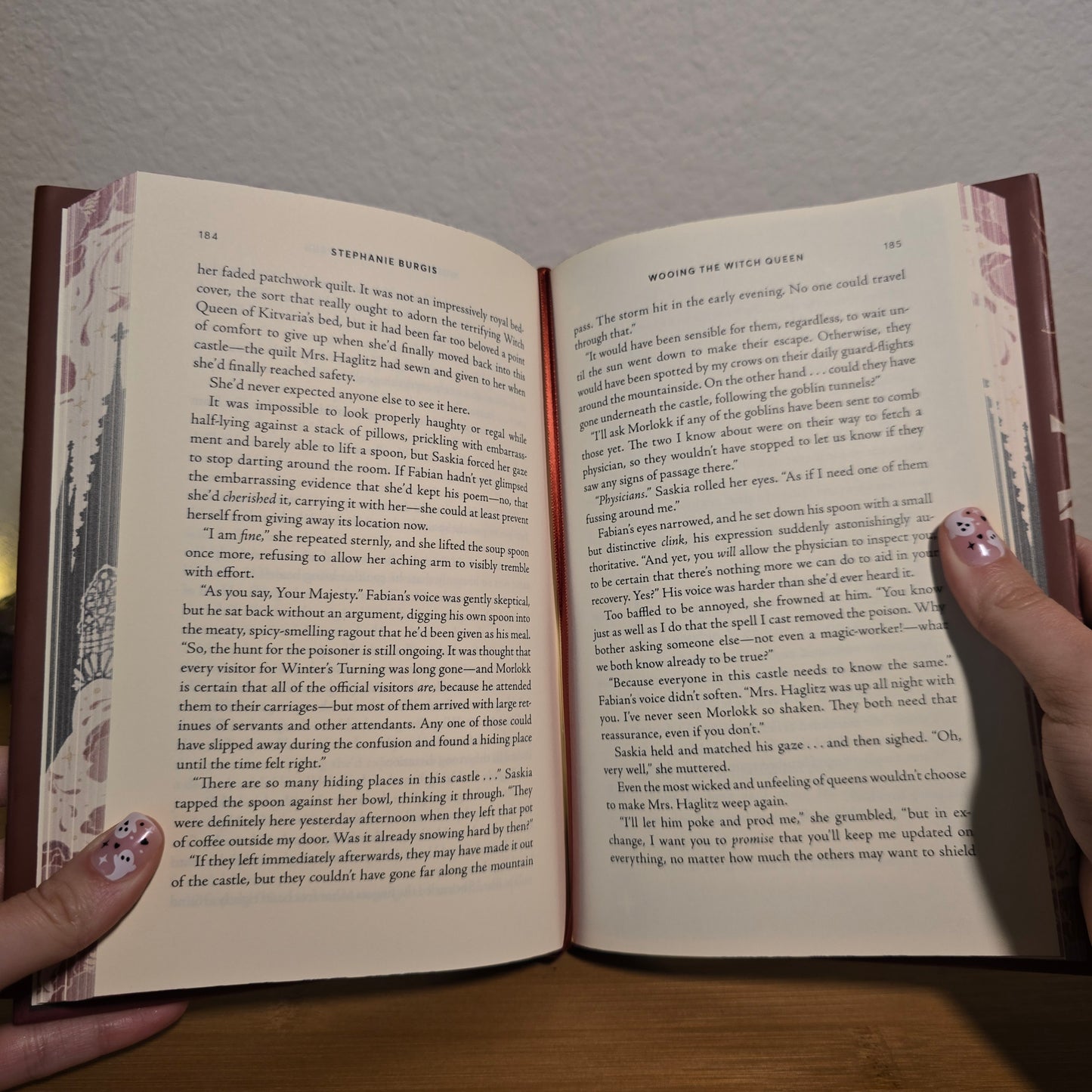 Open book held by a person with visible text and decorative cover