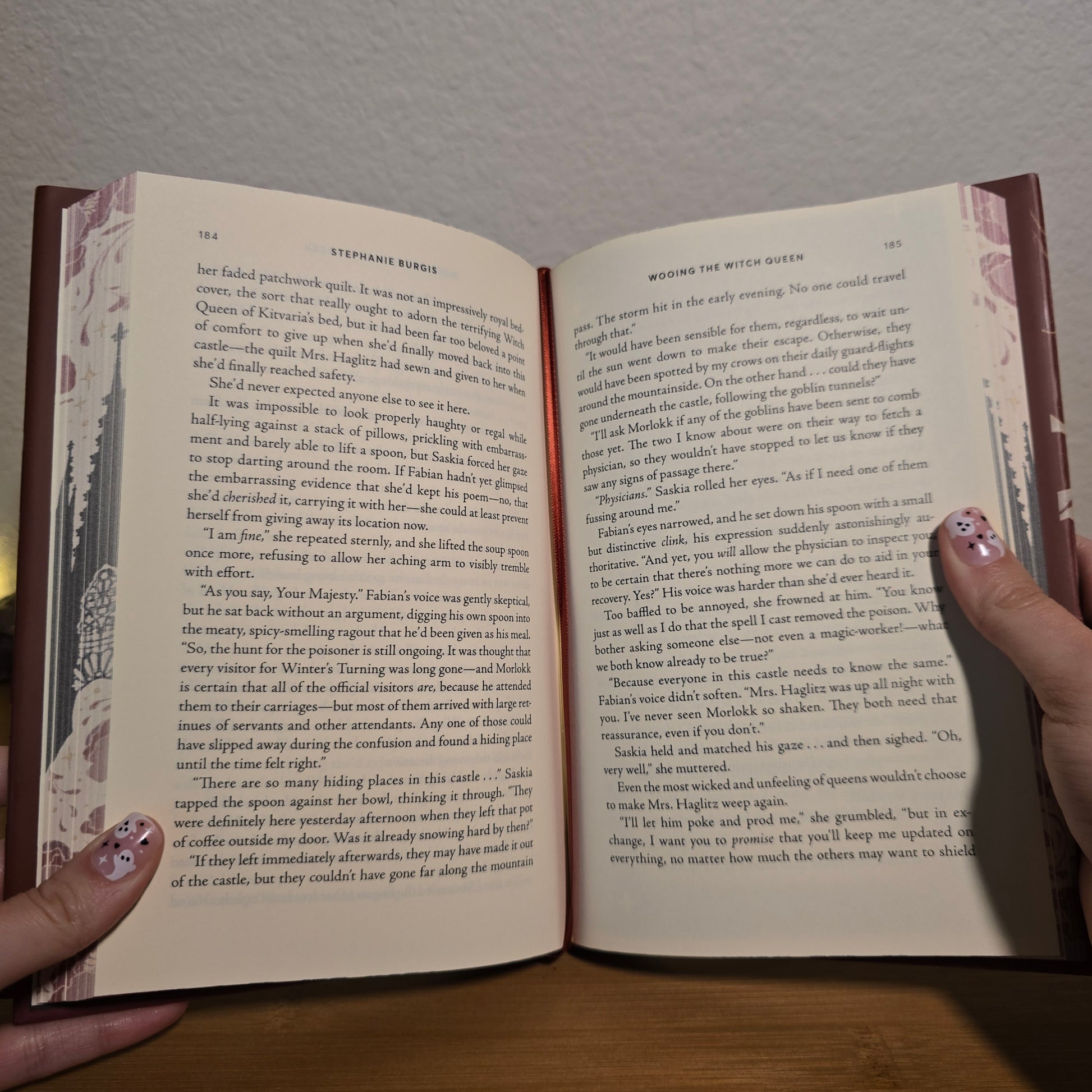 Open book held by a person with visible text and decorative cover